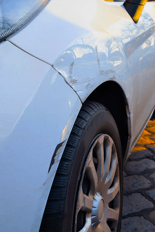 пошкоджене ліве переднє крило автівки після ДТП